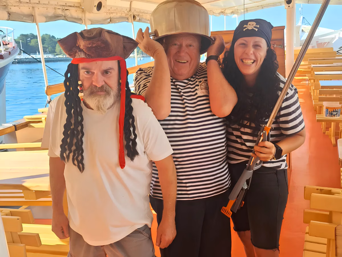 Guests laughing together in pirate costumes aboard the boat